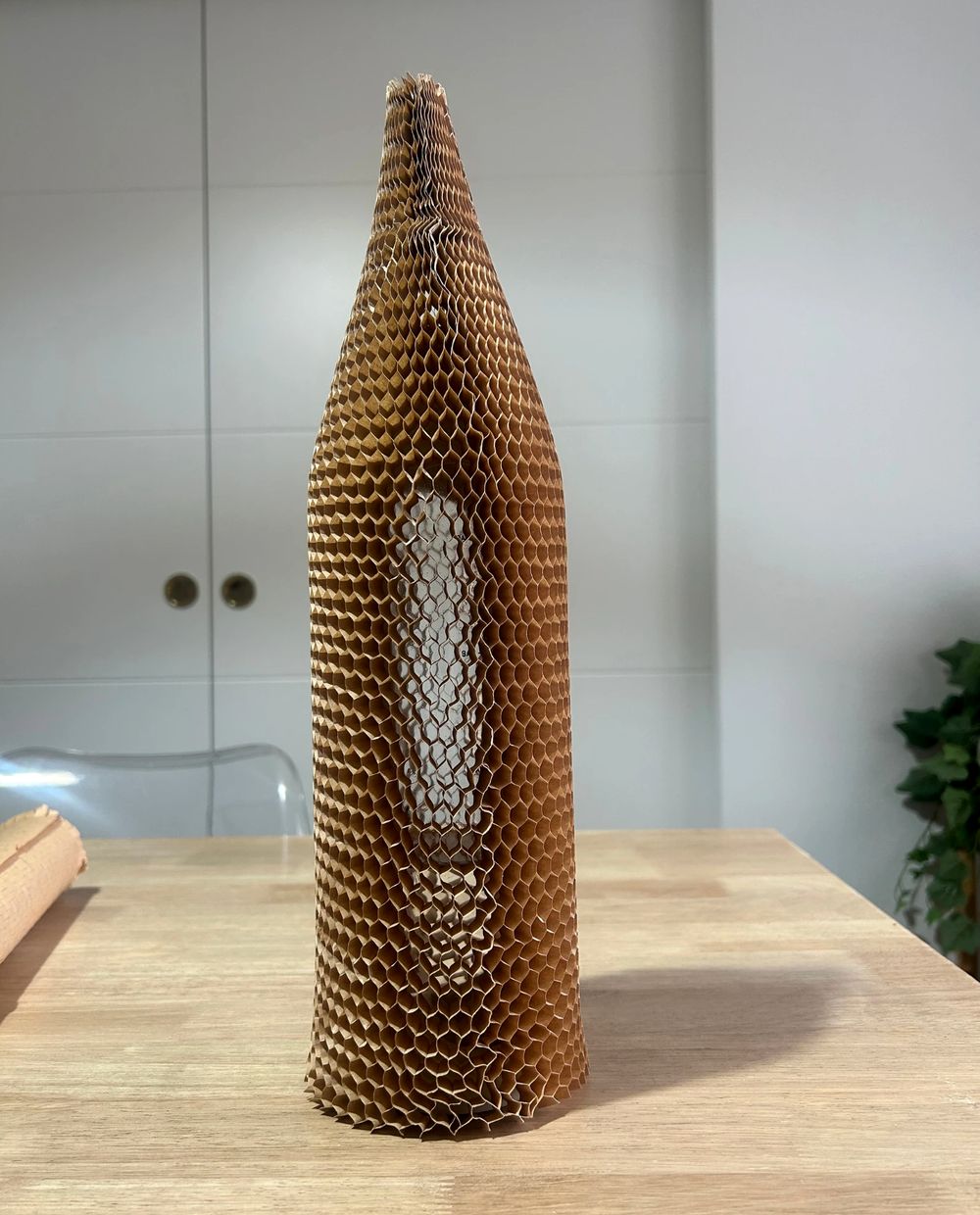 Botella de vidrio protegida con una funda de papel nido de abeja