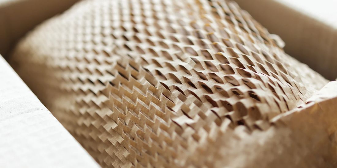 Papel nido de abeja kraft protegiendo un producto dentro de una caja de envío
